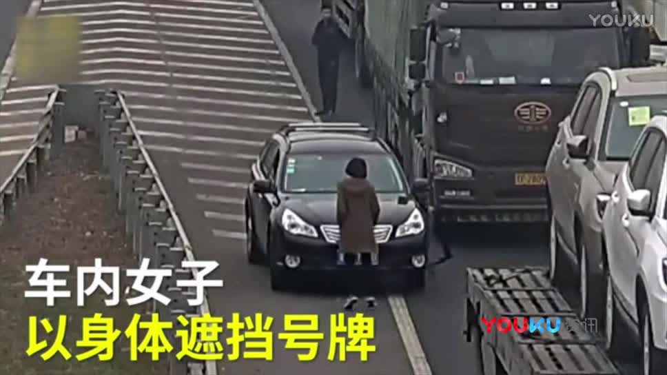 司机高速路上倒车随车美女竟跳操挡车牌